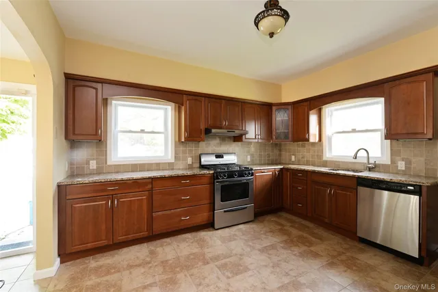 a kitchen with stainless steel appliances granite countertop a sink stove and window