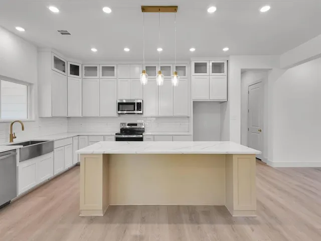 a view of an empty room with wooden floor fireplace and a window