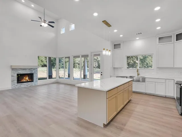 a large kitchen with stainless steel appliances lots of counter top space and a sink