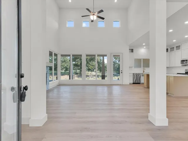 wooden floor in an empty room with a kitchen view