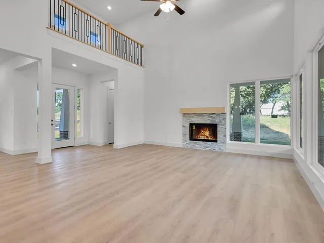 a view of kitchen with kitchen island granite countertop wooden floor stainless steel appliances and cabinets