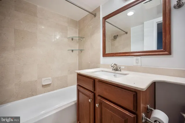 a bathroom with a tub sink vanity and a mirror
