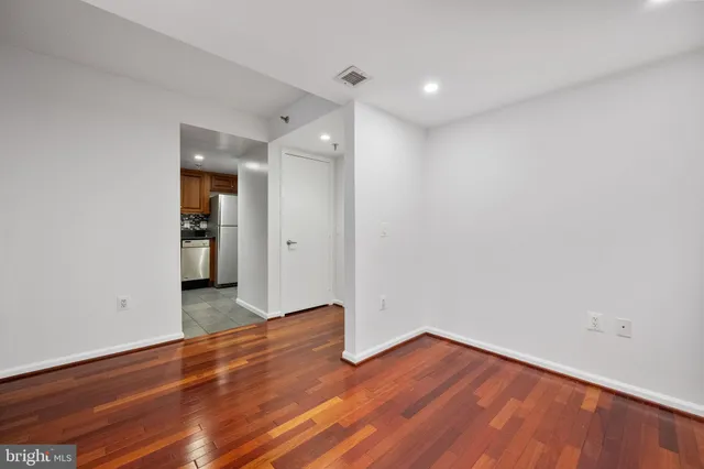 a view of a room with wooden floor and white walls