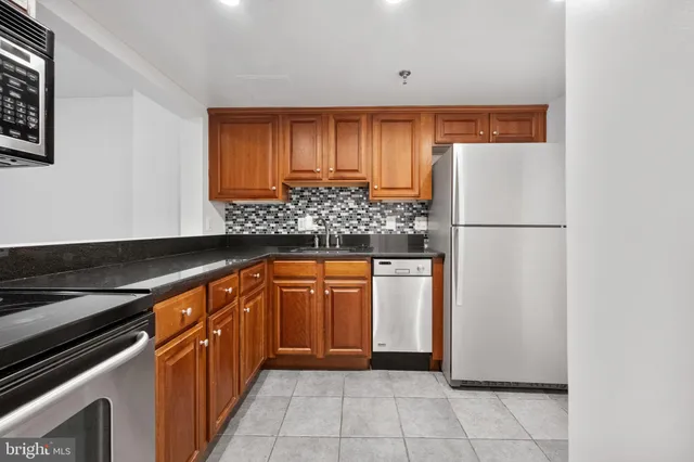 a kitchen with stainless steel appliances granite countertop a refrigerator and a sink