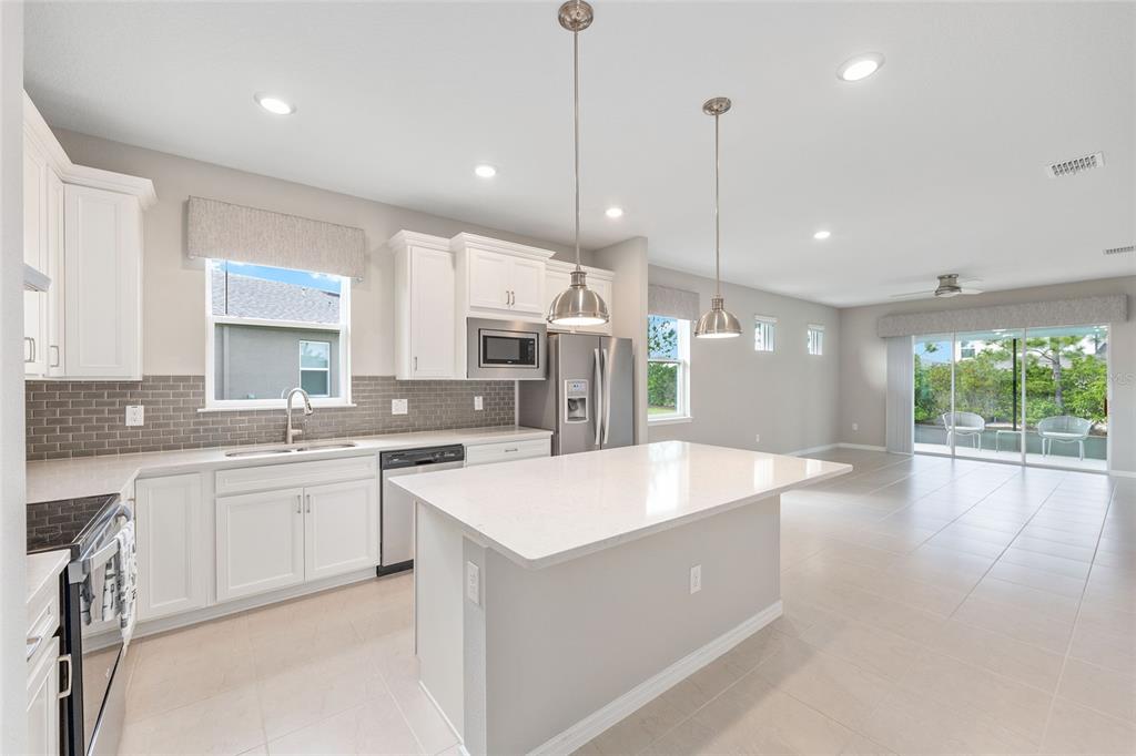 5966 Southwest 93rd Circle Ocala, FL 34481 - Photo 18 of 41 a large kitchen with kitchen island a large island in it