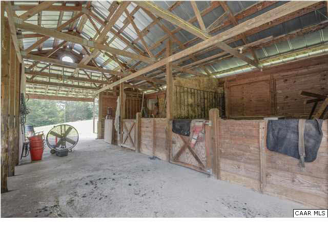 3938 Richmond Road Keswick, VA 22947 - Photo 31 of 37 A center aisle barn is set well-back in the pasture away from the home. Open post & beam construction, built on a concrete pad with high metal ceiling and covered entry area, it has electricity and plumbing.