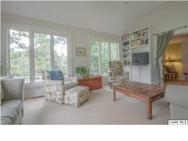 3938 Richmond Road Keswick, VA 22947 - Photo 10 of 37 French doors create a graceful opening to the sunroom, allowing light to stream through, even when closed for privacy. The stairwell to the upstairs master suite, lit by a window, is discreetly tucked behind a door.