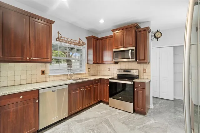 a kitchen with stainless steel appliances granite countertop a stove microwave and sink