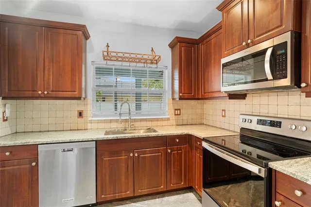 a kitchen with stainless steel appliances granite countertop a sink stove and microwave