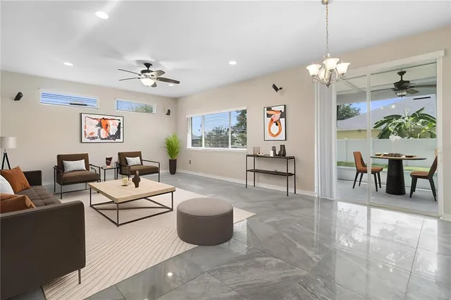 a living room with furniture a chandelier and a flat screen tv