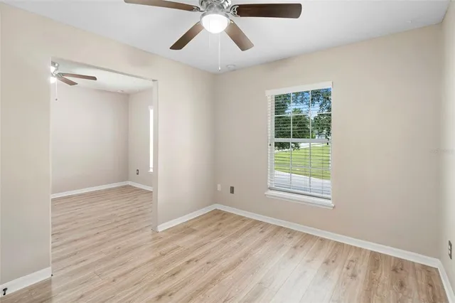an empty room with a window and wooden floor