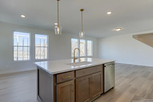 a kitchen with granite countertop a stove sink and refrigerator