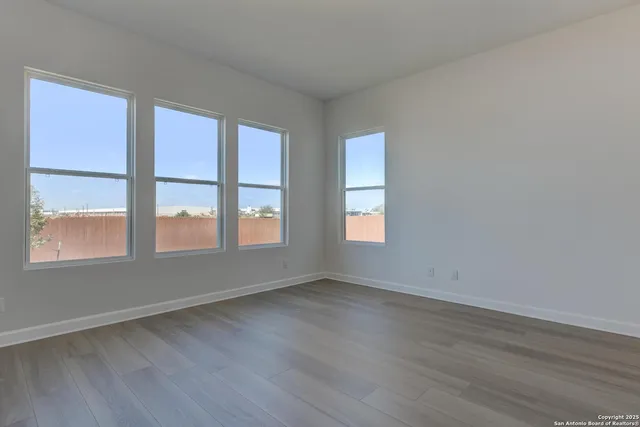 a view of an empty room with wooden floor