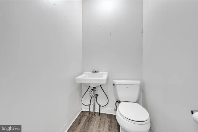 a white toilet sitting next to a white sink and a small table