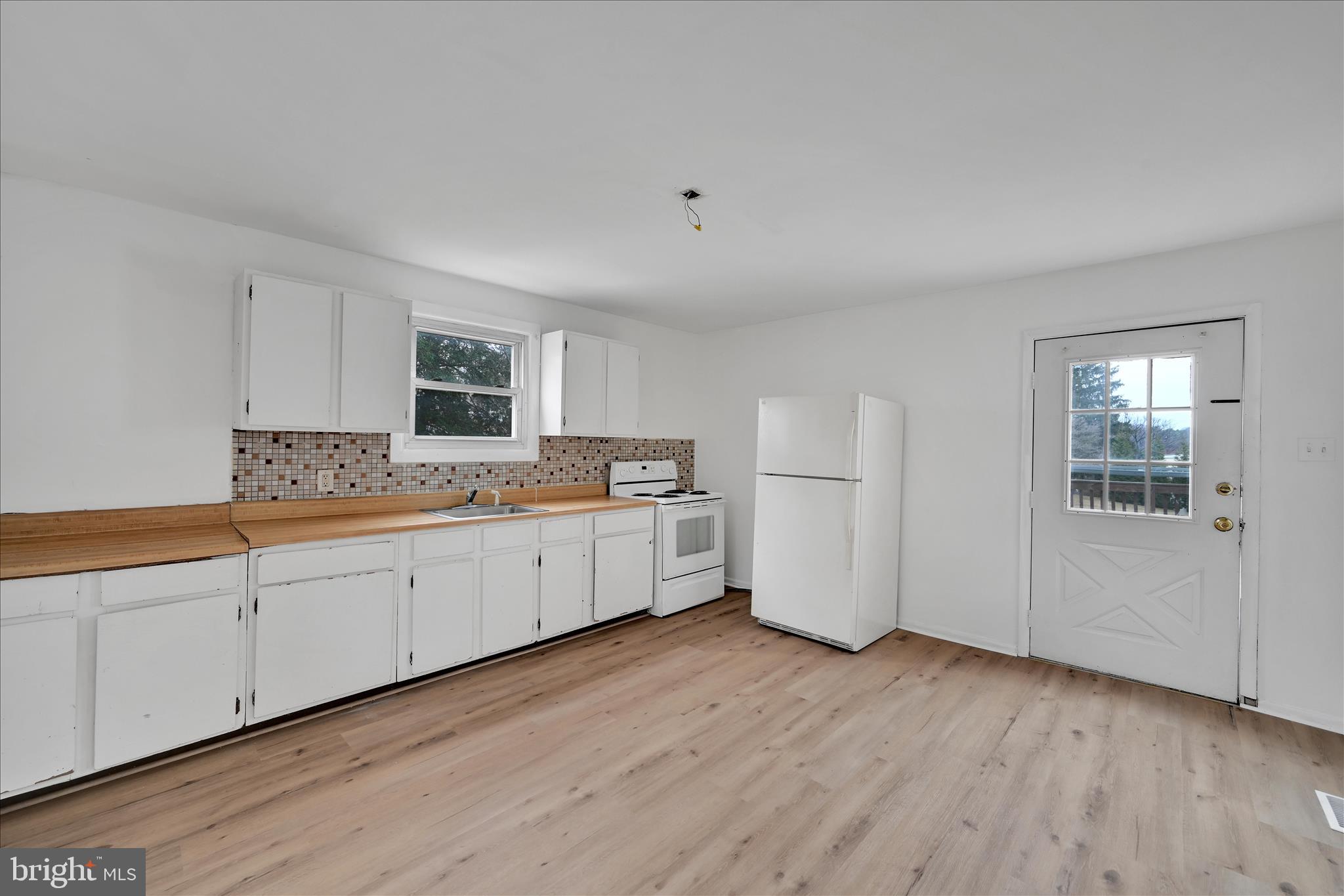 4301 Aston Mills Road Aston, PA 19014 - Photo 17 of 33 a large white kitchen with white cabinets and wooden floor