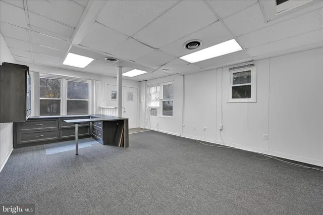 a view of an empty room with window and a ceiling fan