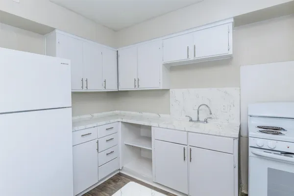 a kitchen with white cabinets and white appliances