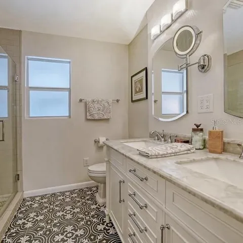 a bathroom with a granite countertop sink mirror vanity and a toilet