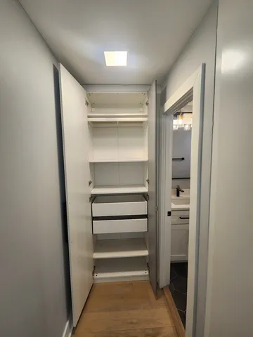 a view of walk in closet with empty racks