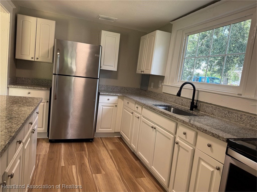 111 D Street Frostproof, FL 33843 - Photo 18 of 40 a kitchen with a refrigerator sink and cabinets