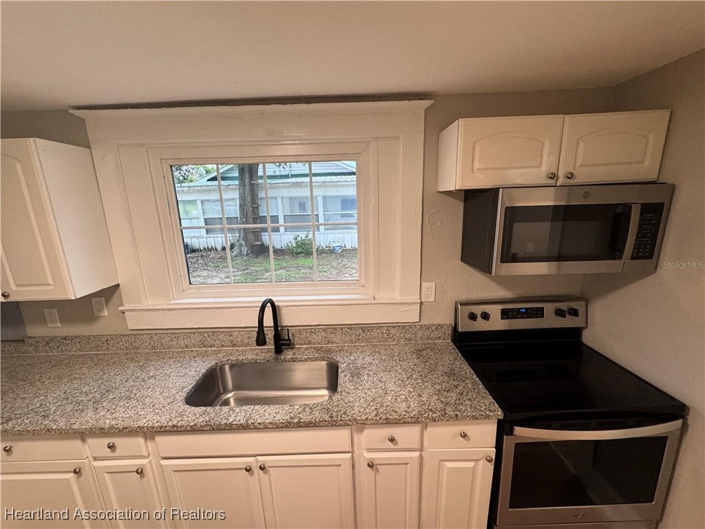 111 D Street Frostproof, FL 33843 - Photo 21 of 40 a kitchen with stainless steel appliances granite countertop a sink and a stove