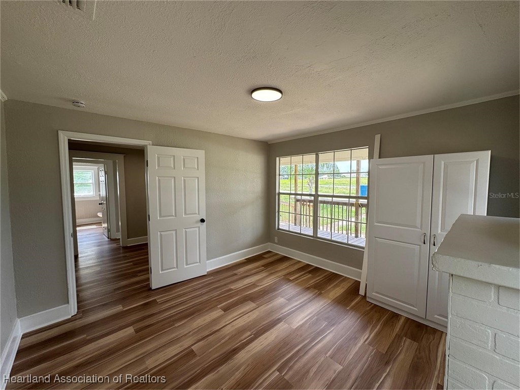 111 D Street Frostproof, FL 33843 - Photo 8 of 40 wooden floor in an empty room with a window