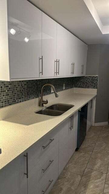 4167 Haverhill Road, Unit 1107 West Palm Beach, FL 33417 - Photo 5 of 13 a kitchen with a sink and cabinets