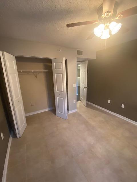 4167 Haverhill Road, Unit 1107 West Palm Beach, FL 33417 - Photo 8 of 13 an empty room with closet and a chandelier fan