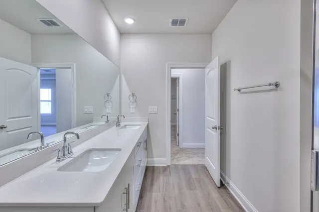 a bathroom with a double vanity sink a mirror and a shower