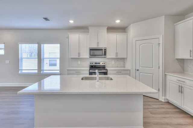 a kitchen with kitchen island white cabinets and stainless steel appliances