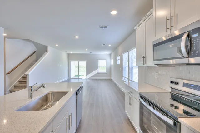 a kitchen with stainless steel appliances granite countertop a sink stove and cabinets