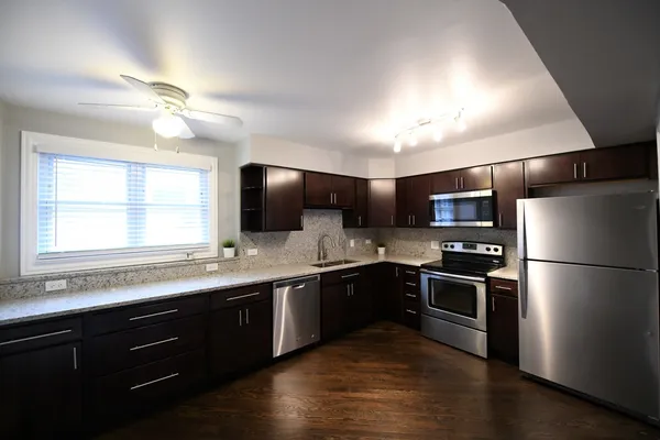 a kitchen with stainless steel appliances granite countertop sink refrigerator and microwave
