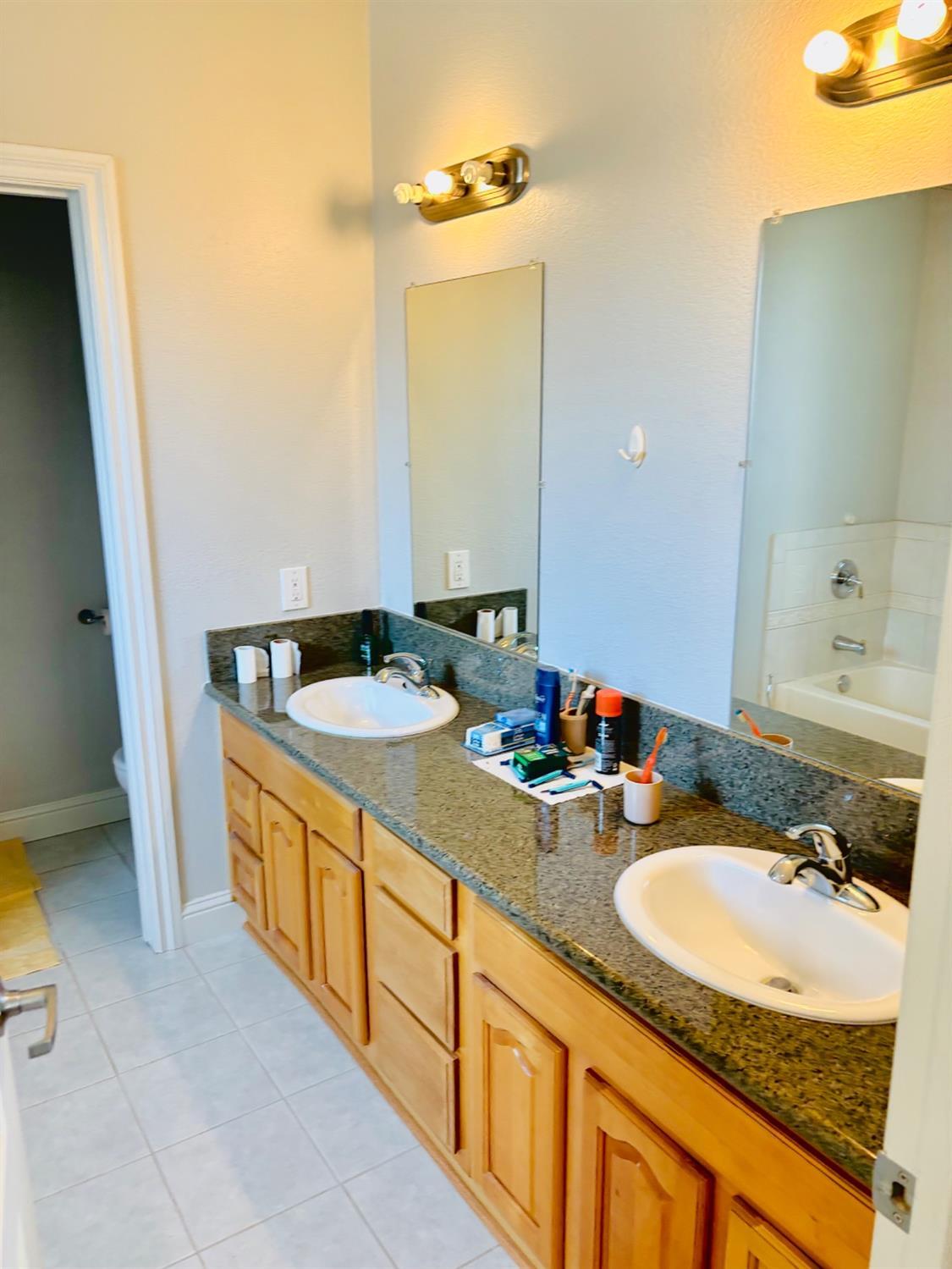 3416 Rio Linda Boulevard Sacramento, CA 95838 - Photo 11 of 13 a bathroom with a granite countertop sink and a mirror