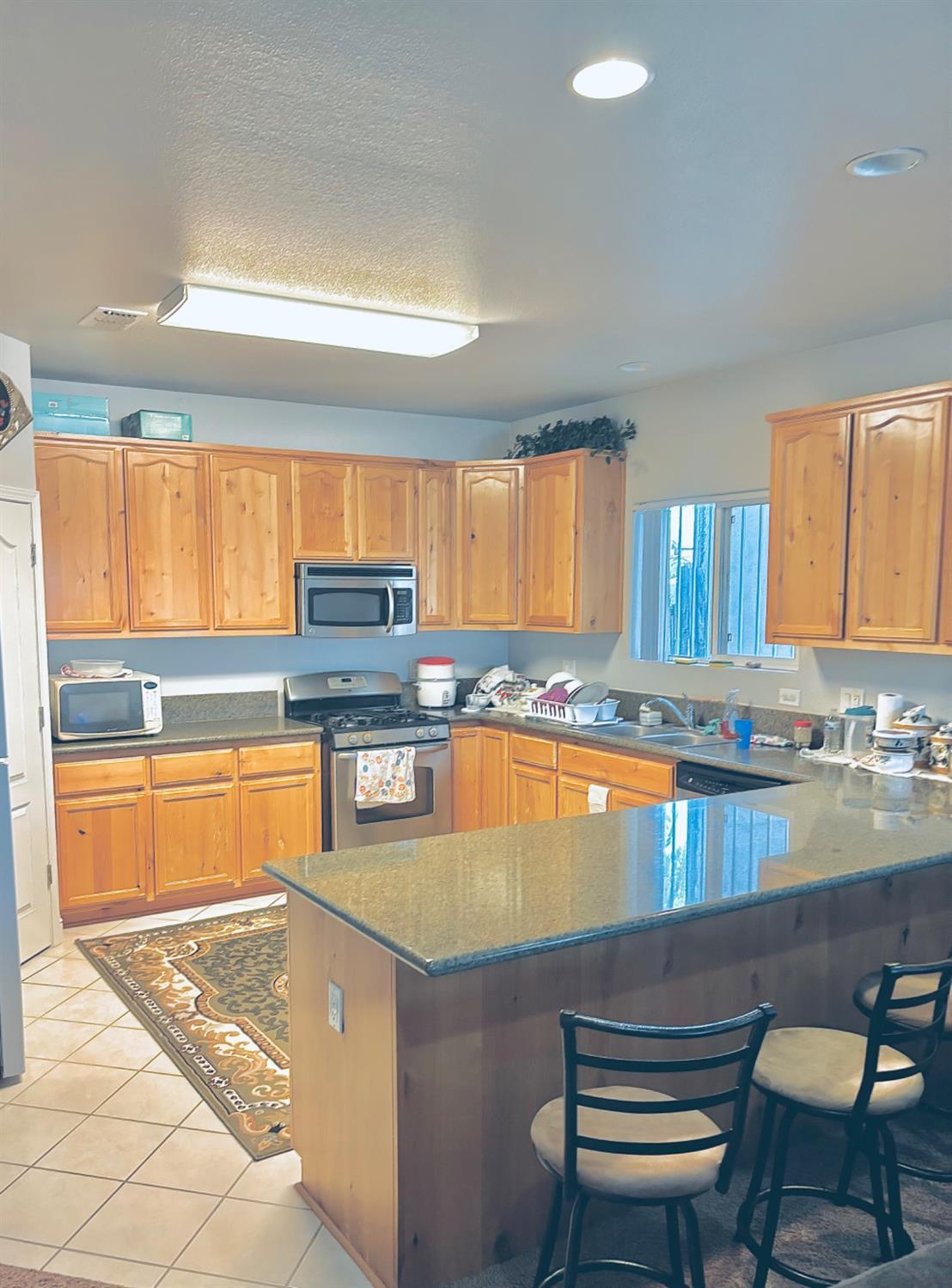 3416 Rio Linda Boulevard Sacramento, CA 95838 - Photo 7 of 13 a kitchen with stainless steel appliances granite countertop a stove a sink and a granite counter tops with a large window
