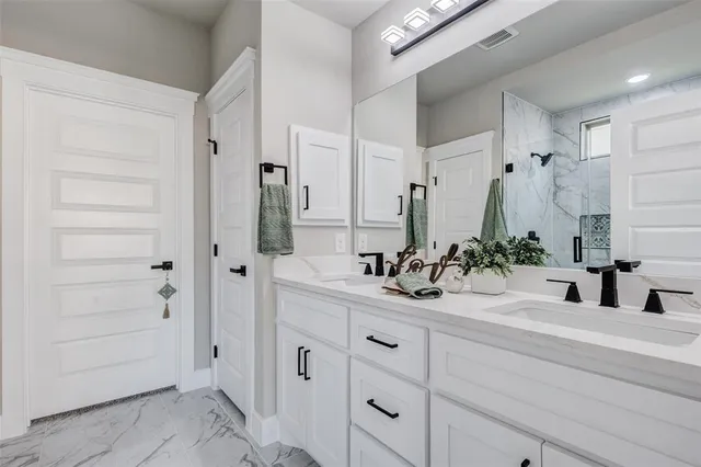 a bathroom with double vanity sink and mirror