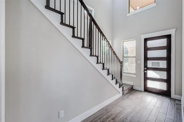 a view of a hallway with wooden floor and entryway