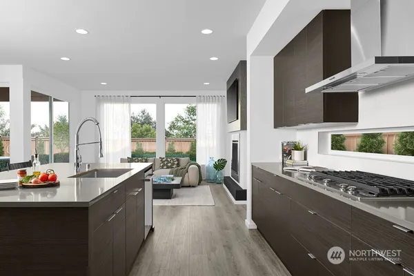 a living room with stainless steel appliances granite countertop a sink a stove and a refrigerator