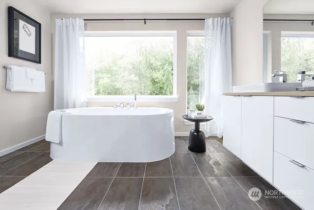 a white bath tub sitting in a bathroom next to a window