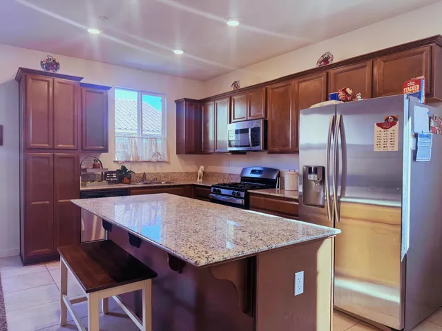 a kitchen with stainless steel appliances granite countertop a sink refrigerator and microwave