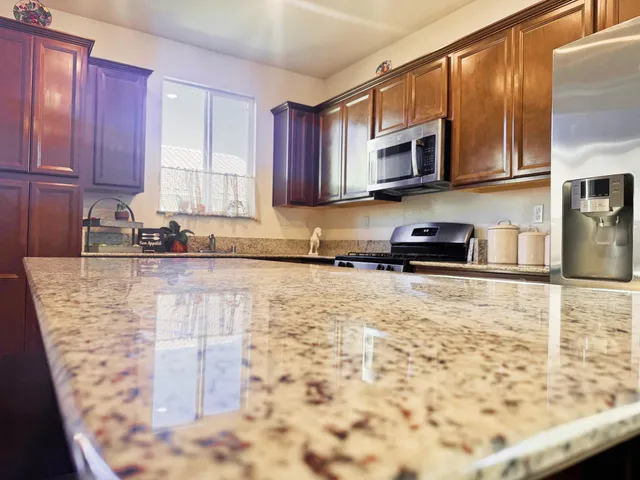 a kitchen with stainless steel appliances granite countertop a stove a sink a microwave and a refrigerator