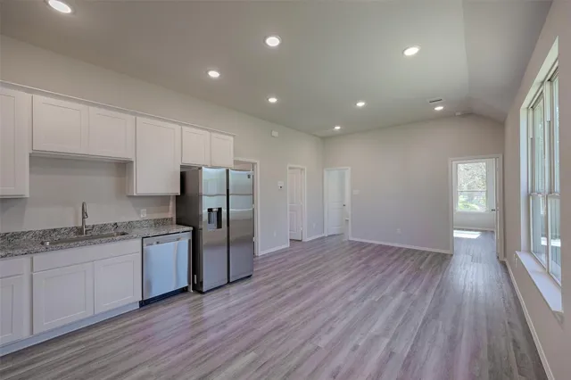 a kitchen with stainless steel appliances granite countertop a refrigerator and a sink