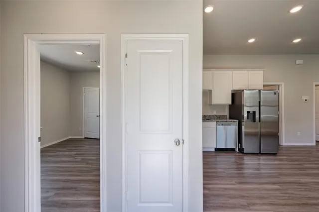 a view of kitchen with refrigerator cabinets and wooden floor