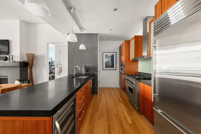 a large kitchen with stainless steel appliances a sink a stove and a refrigerator