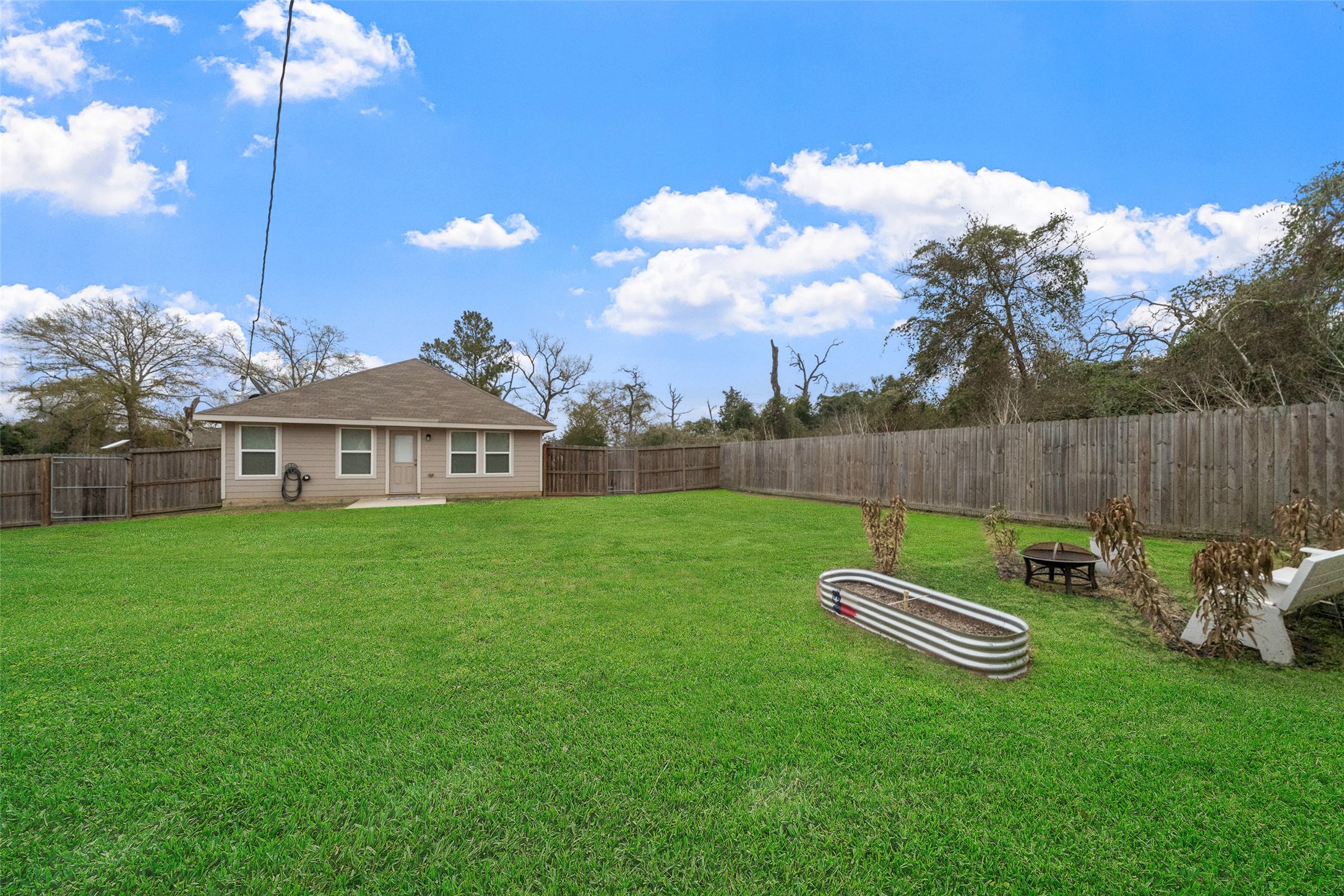 26431 Pin Oak Drive Hempstead, TX 77445 - Photo 4 of 32 Expansive fenced backyard with plenty of open green space for play, pets, or entertaining. Grass has been digitally enhanced for marketing purposes.