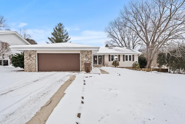 a front view of a house with a yard covered with snow and palm trees