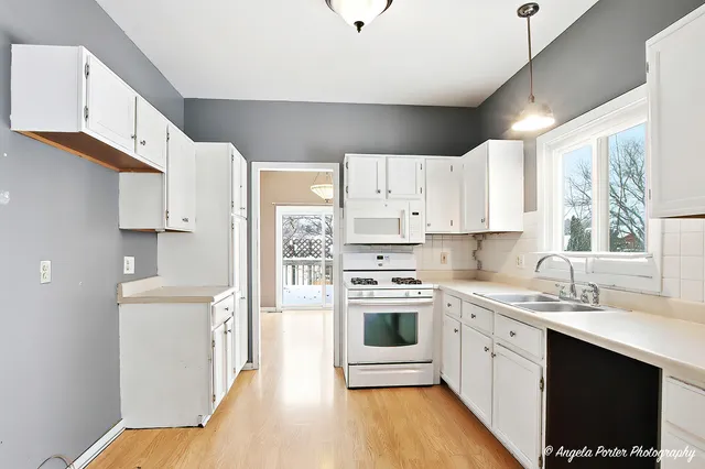 a kitchen with stainless steel appliances white cabinets a sink a stove a refrigerator and cabinets