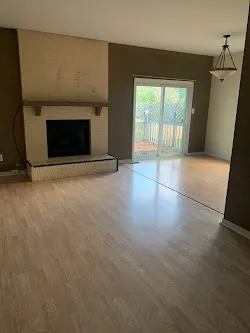 an empty room with windows and fireplace