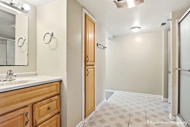 a bathroom with a granite countertop sink mirror and a shower