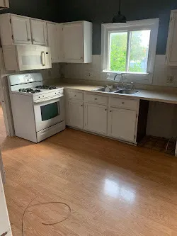 a kitchen with a stove a sink and a window