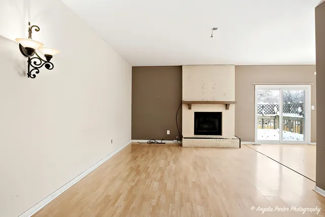 a view of an empty room with a fireplace and a window